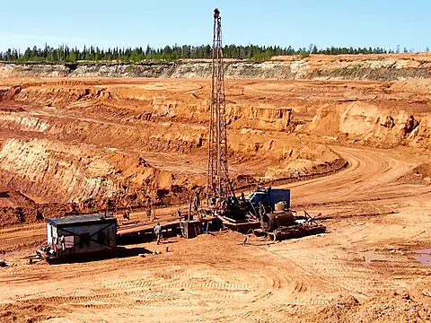 Drill rig working on a bench in an open-pit mine